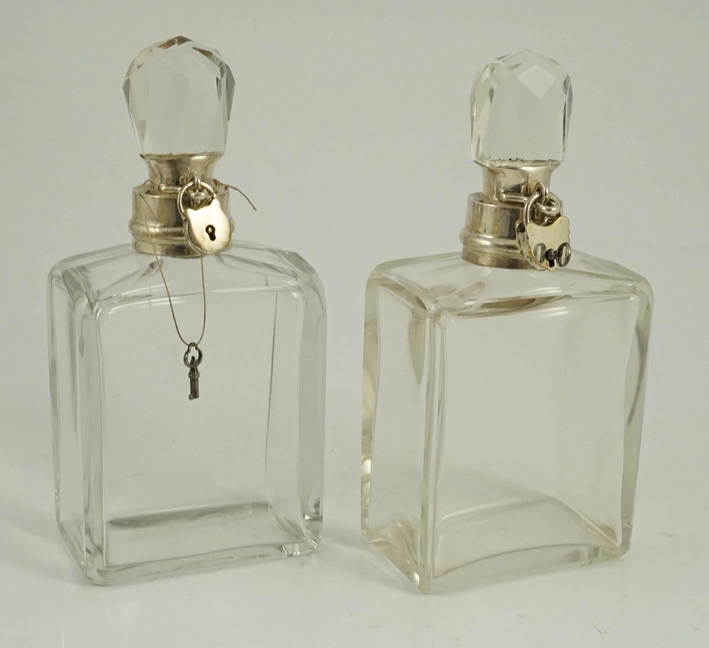 A pair of George V Hukin & Heath silver mounted glass lockable decanters and stoppers, with padlock and key